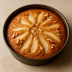 A golden spiced pear cake with sliced pears and toasted almonds